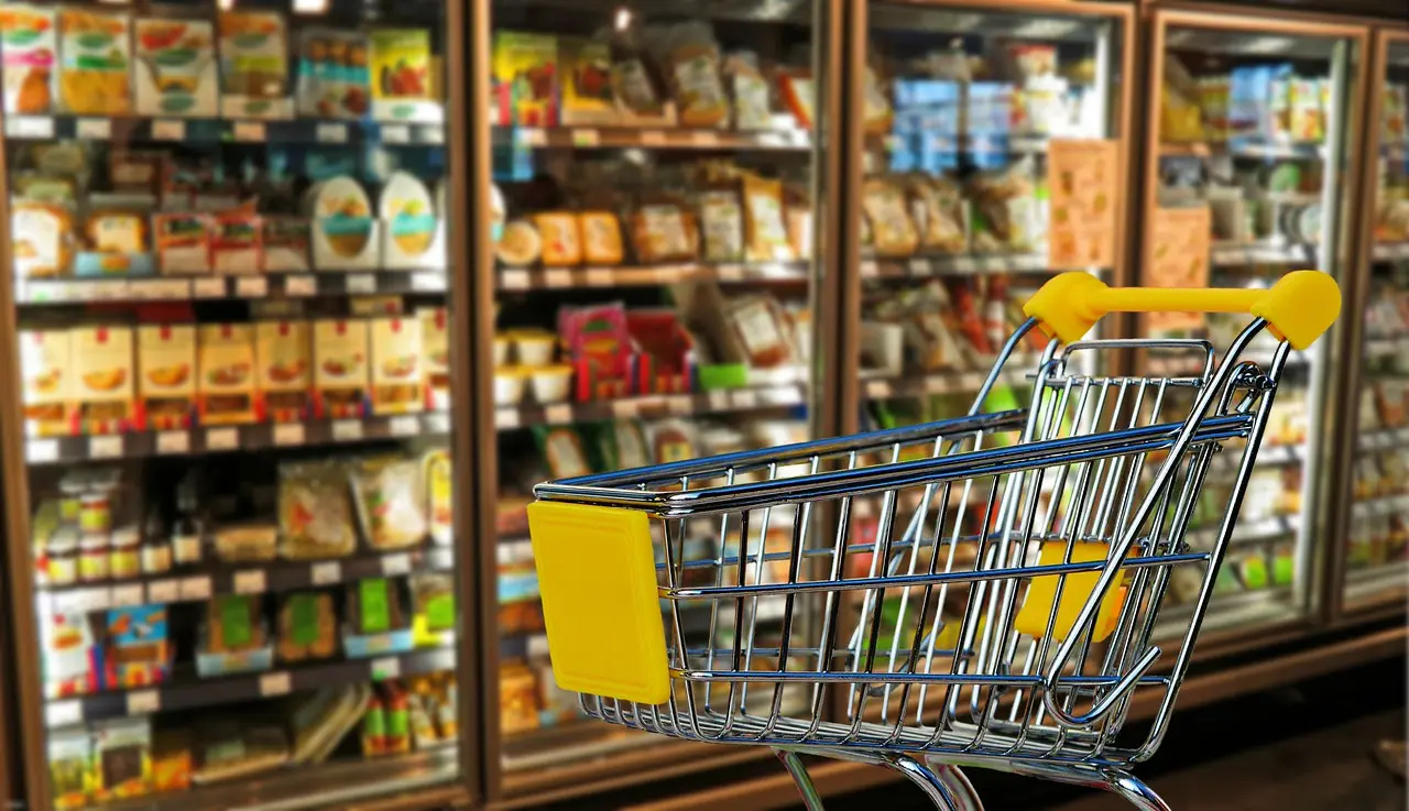 Einkaufswagen vor einem Regal im Supermarkt